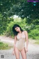 A woman in a gold bathing suit posing for a picture.