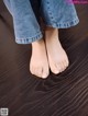 A person standing on a wooden floor with their bare feet.