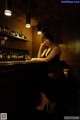 A woman sitting at a bar with a glass of wine.