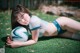 A woman laying on the grass with a soccer ball.