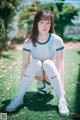 A woman sitting on the ground with a soccer ball.