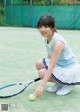 A woman kneeling on a tennis court holding a tennis racket.