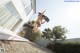 A woman jumping in the air in front of a house.