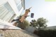 A woman jumping in the air in front of a house.