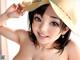 A woman in a straw hat is posing for a picture.