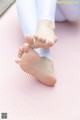 A woman's feet on a pink yoga mat.