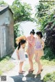 A group of women standing next to each other on a dirt road.