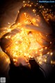 A woman laying on top of a bed covered in lights.