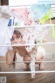 A young girl is hanging out her underwear on a clothes line.