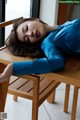 A woman laying on top of a wooden table.