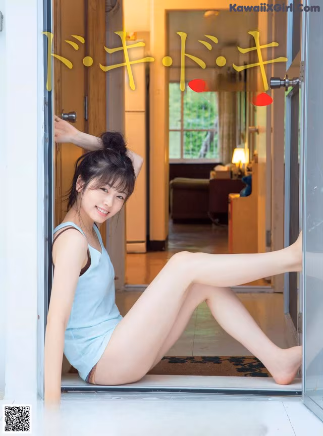 A woman sitting on the floor in front of a door.
