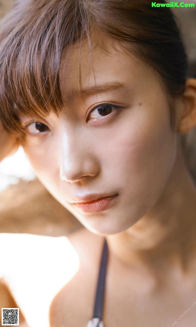 A young woman with brown hair is posing for a picture.