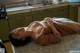 A woman laying on top of a table in a kitchen.