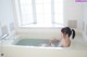 A woman sitting in a bathtub with water in it.