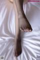 A close up of a person's feet on a bed.