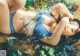 A woman in a blue bikini laying on a bed of flowers.