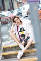 A woman sitting on the steps of a city street.