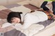 A young woman laying on a bed with her legs up.