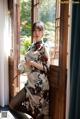 A woman in a cheongsam posing by a window.