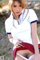 A woman in a white shirt and red skirt posing for the camera.