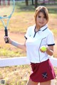 A woman holding a tennis racket and a tennis ball.