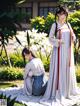 A couple of women standing next to each other in a garden.