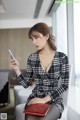 A woman sitting on a chair looking at her phone.