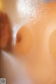 A close up of a person's breasts in a bathtub.