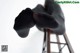 A pair of black tights sitting on top of a wooden chair.