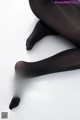 A pair of black tights on a white surface.