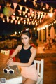 A woman sitting at a table with a pair of sunglasses.