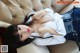 A woman laying on top of a couch wearing jeans and a white shirt.