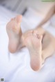 A close up of a person's feet on a bed.